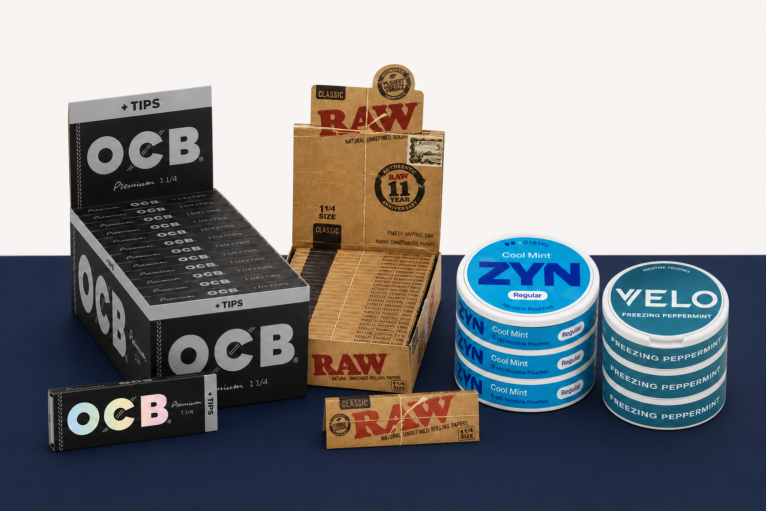 OCB Premium 1 1/4 plus Tips and RAW Classic 1 1/4 display cartons with correctly proportioned ZYN and VELO nicotine pouch cans on a navy display table